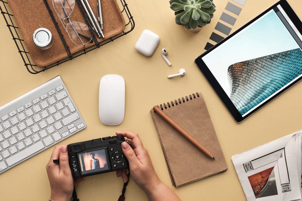pexels-photo-3183132 Overhead view of a modern workspace featuring tech gadgets, a camera, and a notepad.